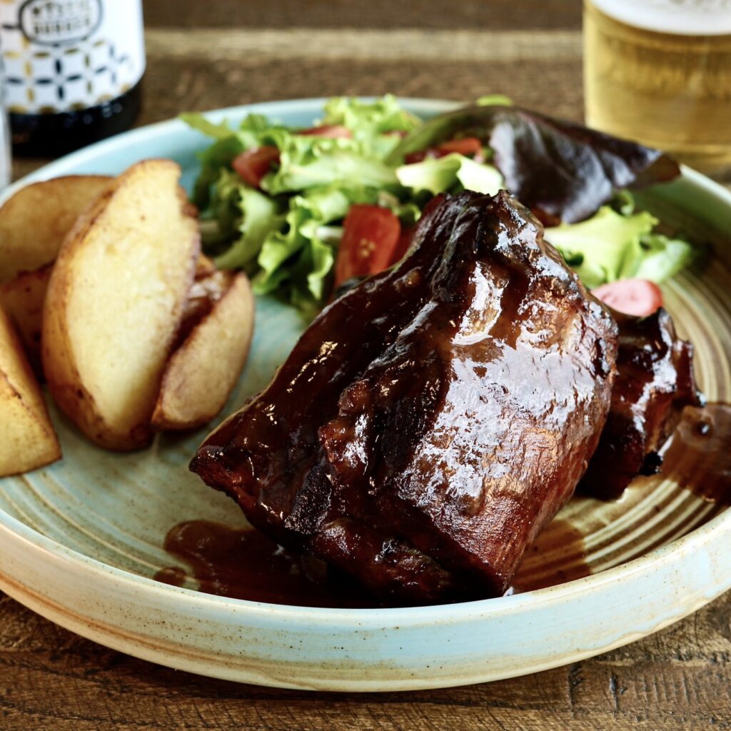 TENERISSIME COSTINE DI MAIALE COTTE A BASSA TEMPERATURA PER 12 ORE CON BARBECUE E MEZCAL, SERVITE CON INSALATA E PATATE AL FORNO.

ALLERGENI: 5,10